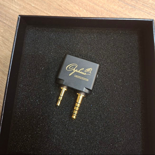 Audio adapter with 'Opheus' branding on a black cushioned base